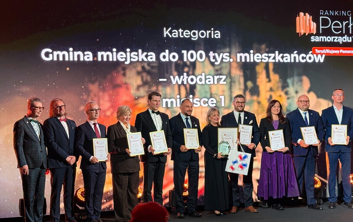 Zdjęcie przedstawia grupę kilkunastu osób z dyplomami stojących w rzędzie