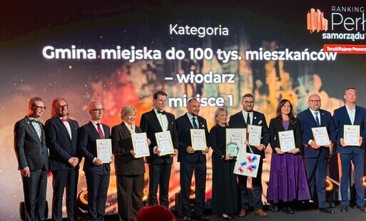 Zdjęcie przedstawia grupę kilkunastu osób z dyplomami stojących w rzędzie