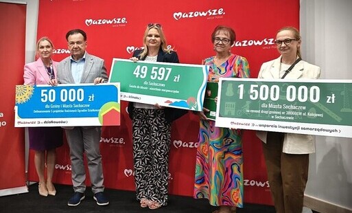 Zdjęcie przedstawia trzy kobiety i mężczyznę trzymających w rękach duże tablice z wysokością kwot