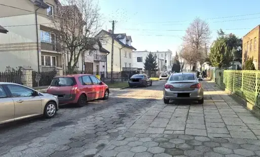Zdjęcie przedstawia ulicę Grabskiego w Sochaczewie przed przebudową, widoczne samochody i budynki